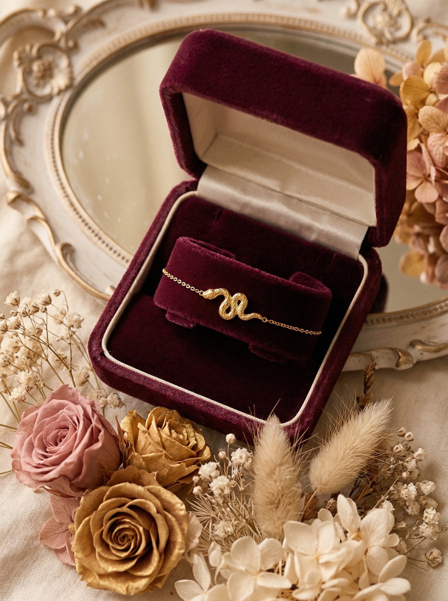 Gold snake charm bracelet styled on a wrist in warm natural light