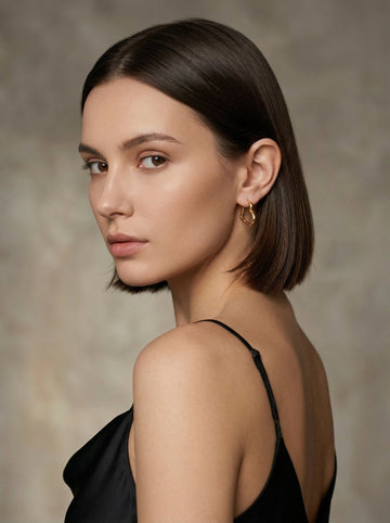 Woman wearing gold hoop earrings with jeans — how to style jewelry with denim