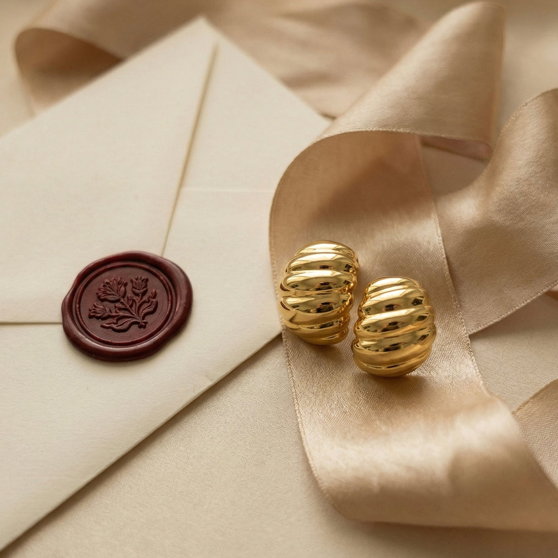 Caia Croissant Huggie Earrings styled in a warm scene