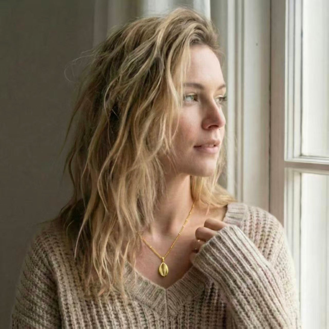 Model wearing a gold pendant necklace with a crew neckline - jewelry and neckline styling guide