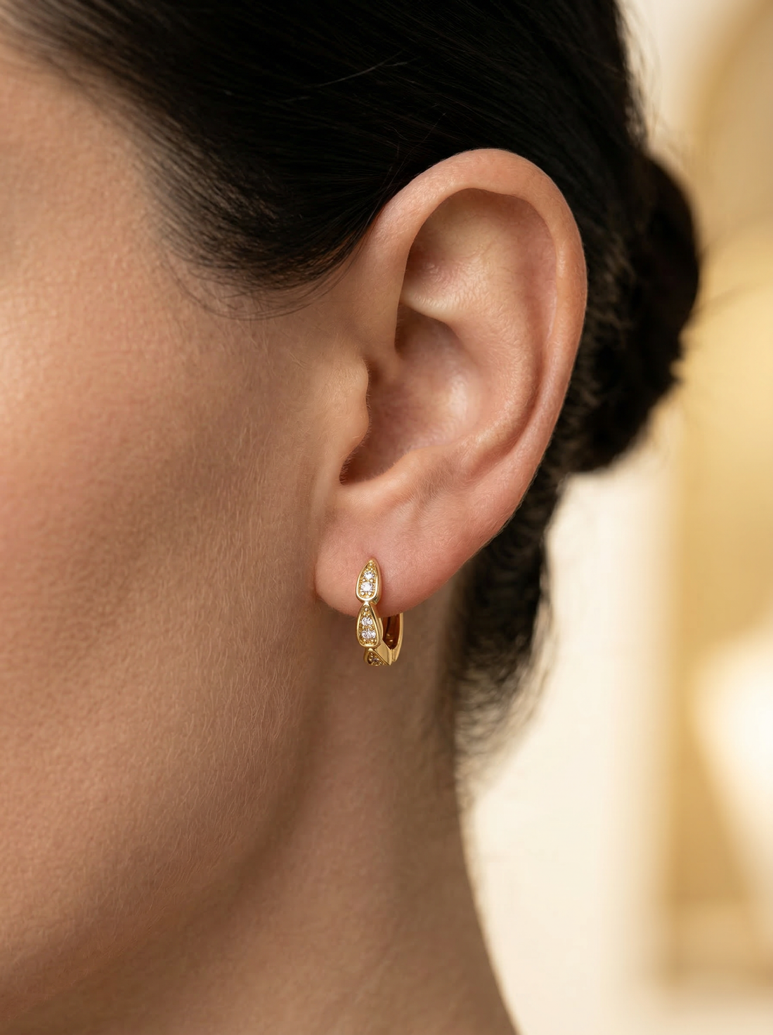 Model wearing Rena Huggie Earrings in gold