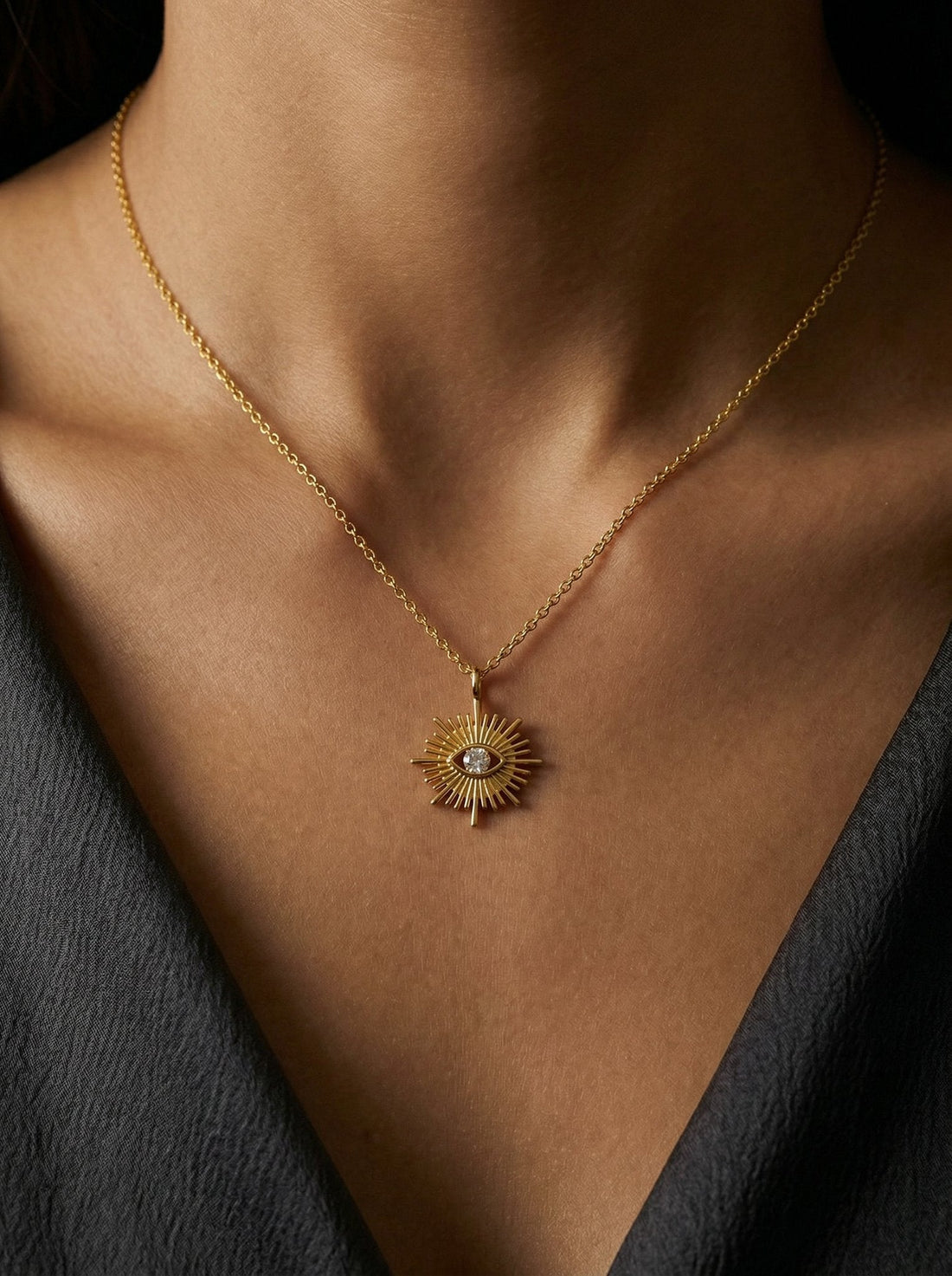 Gold necklace materials guide featuring a sunburst pendant necklace