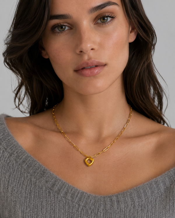 Close-up of gold Remy paperclip chain heart necklace on a model