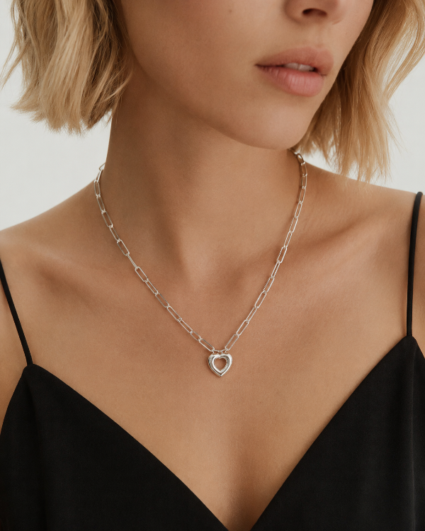 Silver Remy paperclip chain heart necklace worn by a model
